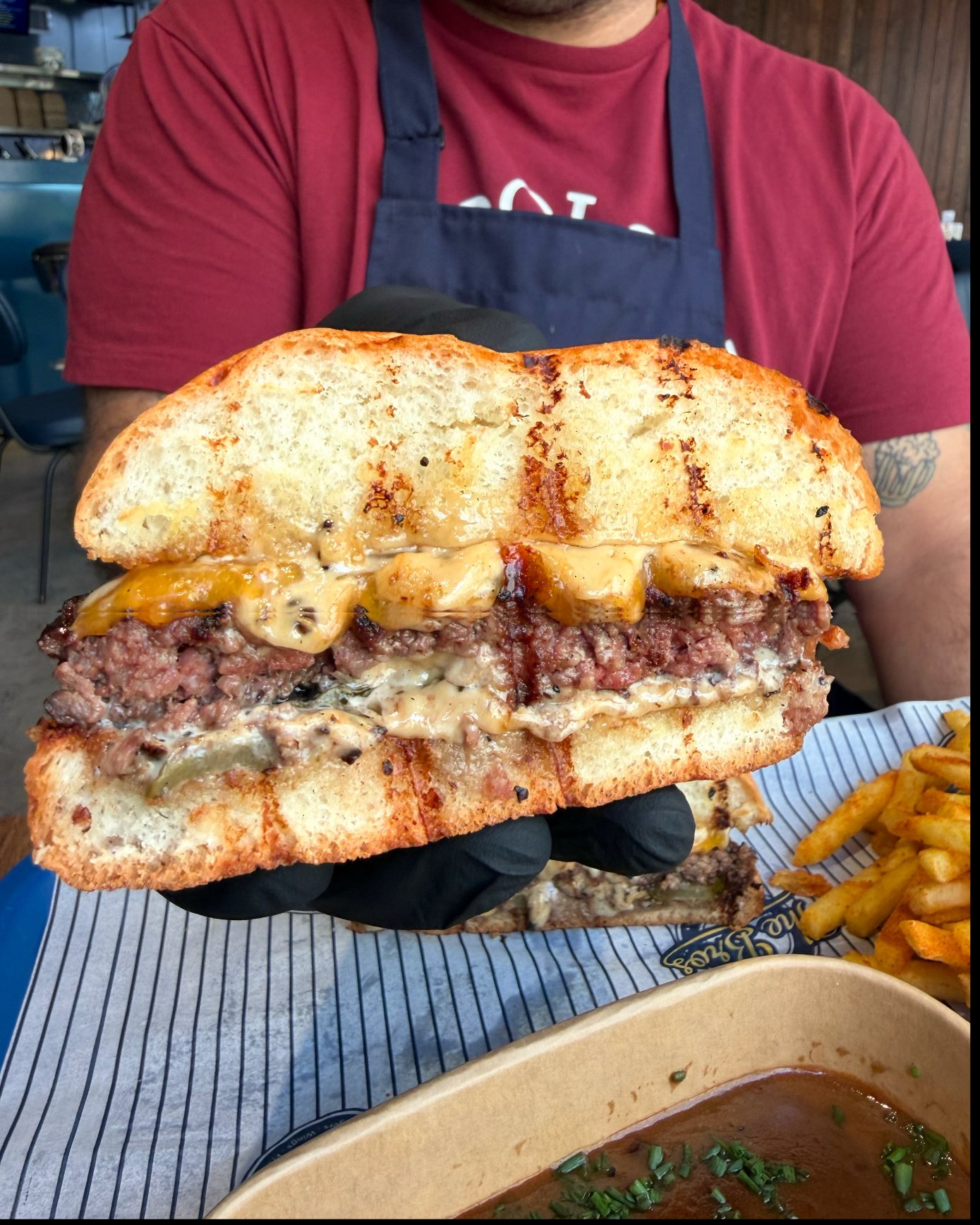 A loaded burger held up to the camera