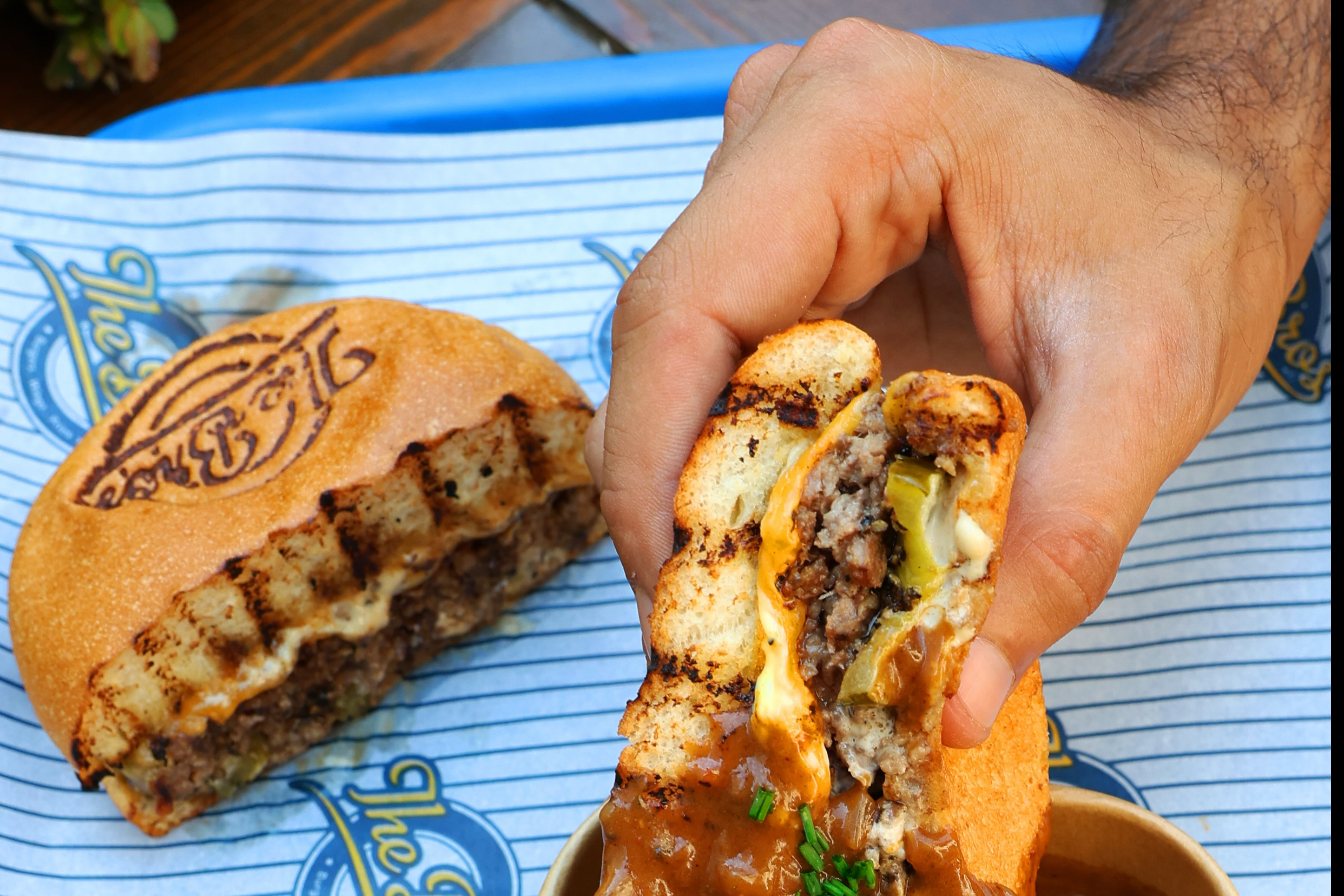 The Frenchie burger with its stamped bun, charred and dunked in peppercorn gravy