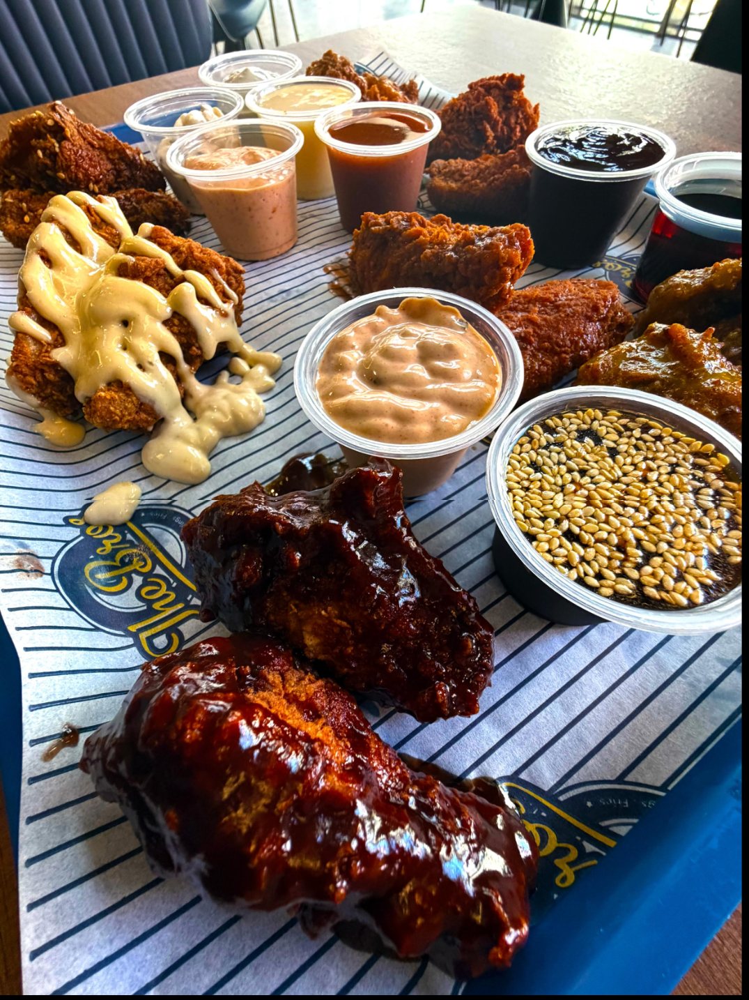 Southern-style wings with house sauces on pinstripe tray paper